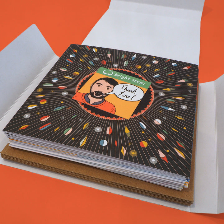 Bright Stem birthday cards and envelopes stacked in an open folder with a thank you card from the artist who designed them.