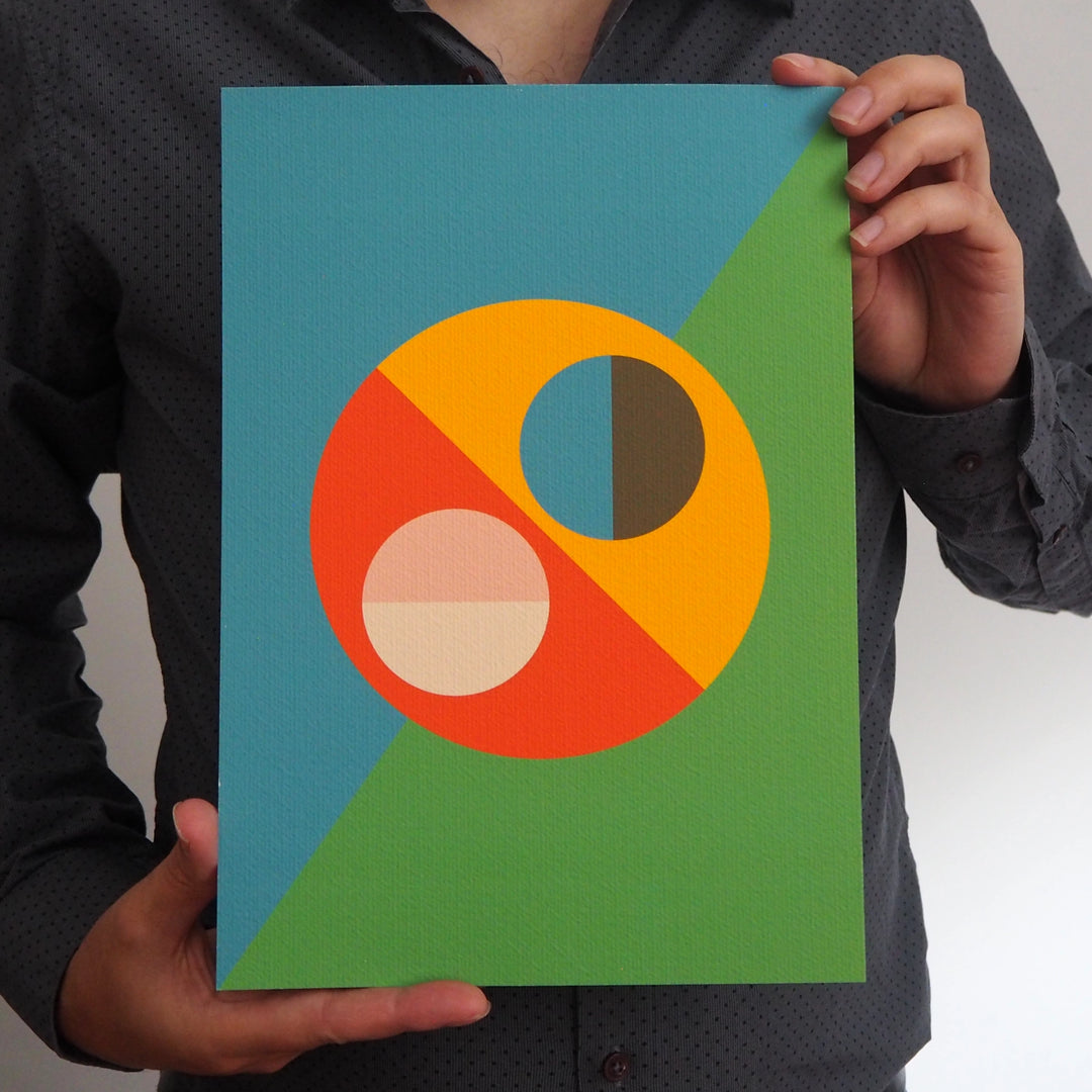 Artist holding a contemporary art print from Bright Stem featuring a colourful geometric design made up of semi circles. 