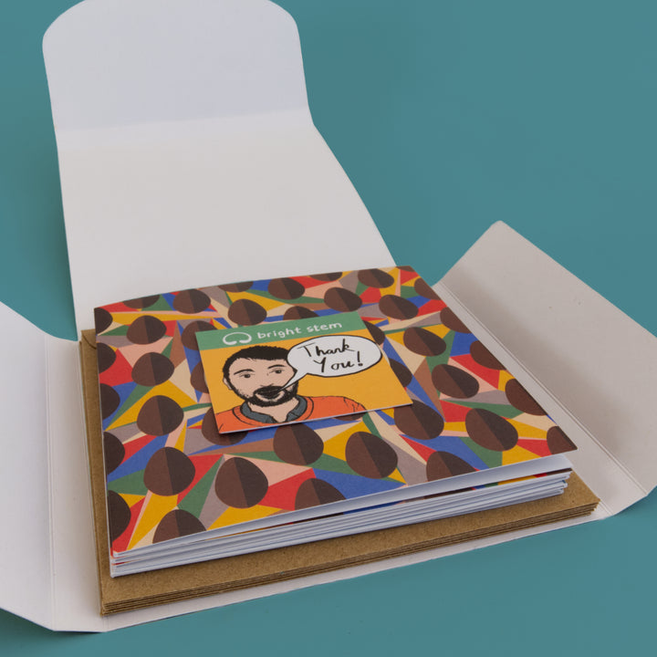 Colourful happy Bright Stem Easter cards with a geometric design in an open folder on a teal background. 6 Pack