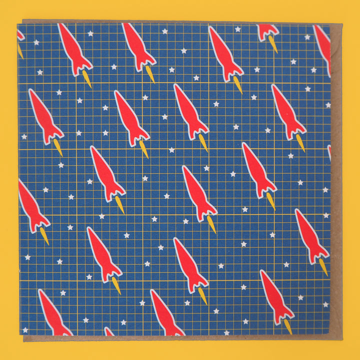Bright Stem Greeting card with sci-fi red space rocket pattern on blue background with brown envelope. Suitable for kids birthday card. flat with envelope inside the greeting card