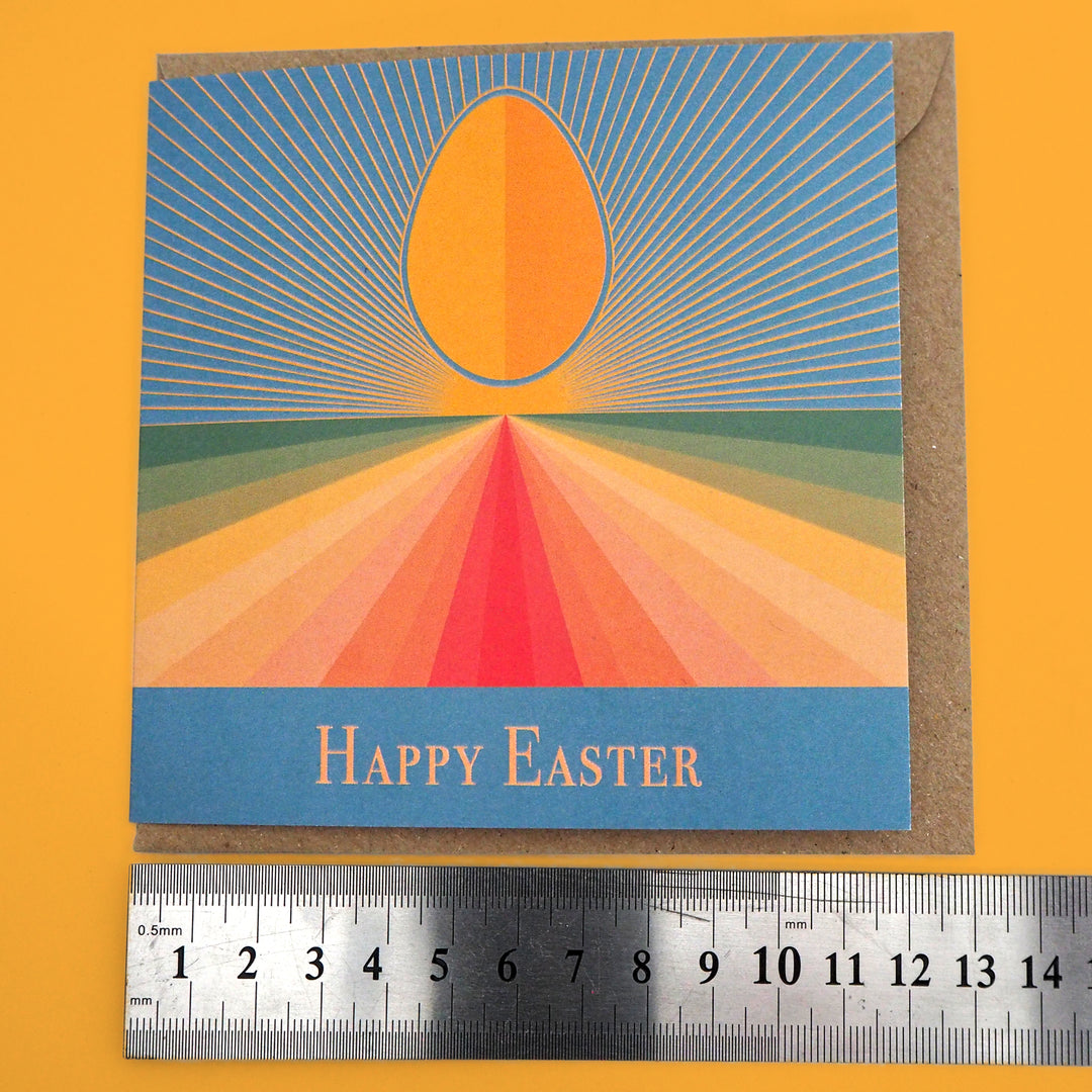 Bright Stem Happy Easter Greeting Card measuring: 12x12cm and  Craft Envelope measuring 13x13cm next to ruler. on yellow background