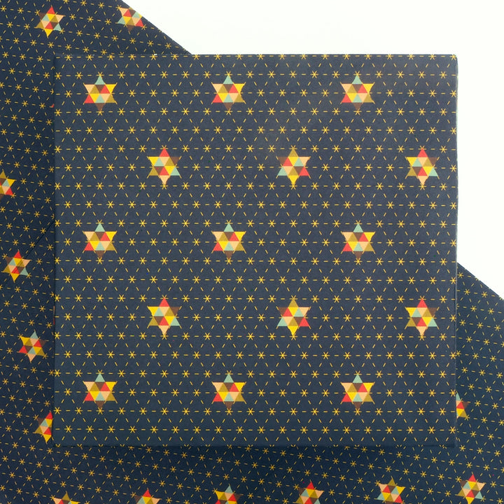Bright Stem Patterned Christmas wrapping paper with colourful star designs on a blue background