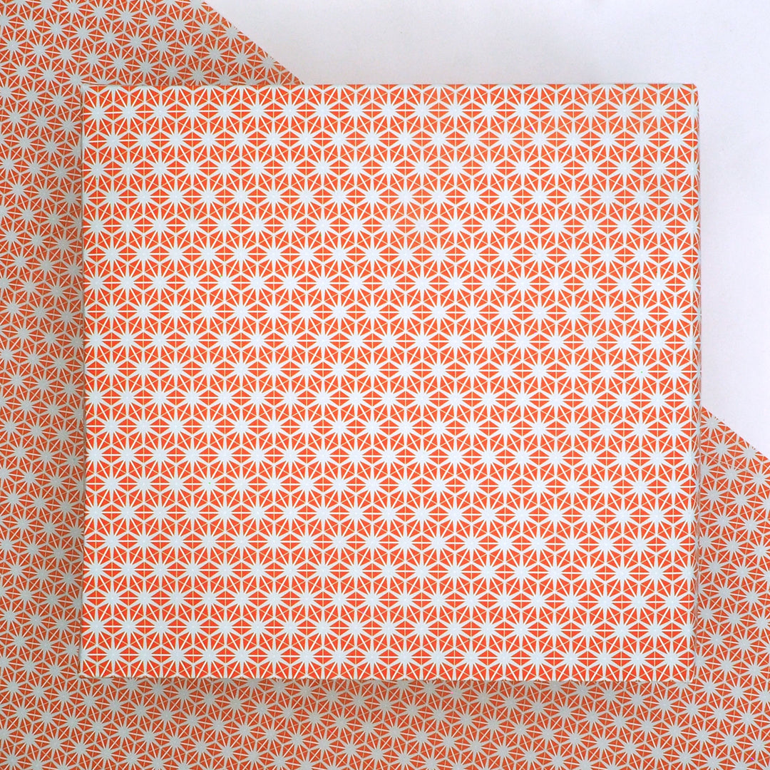 recyclable wrapping paper featuring an orange and grey geometric star pattern   on a matching background