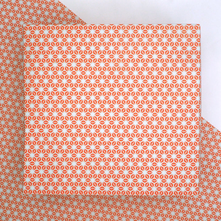 recyclable wrapping paper featuring an orange and grey geometric star pattern   on a matching background