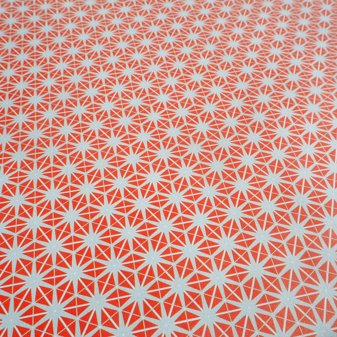 Close up of wrapping paper orange star pattern on grey background 