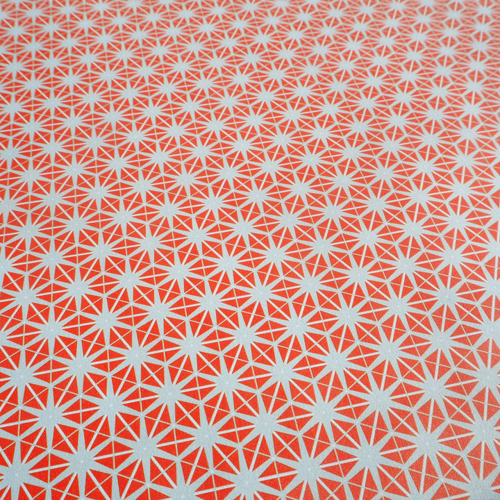 Close up of wrapping paper orange star pattern on grey background 