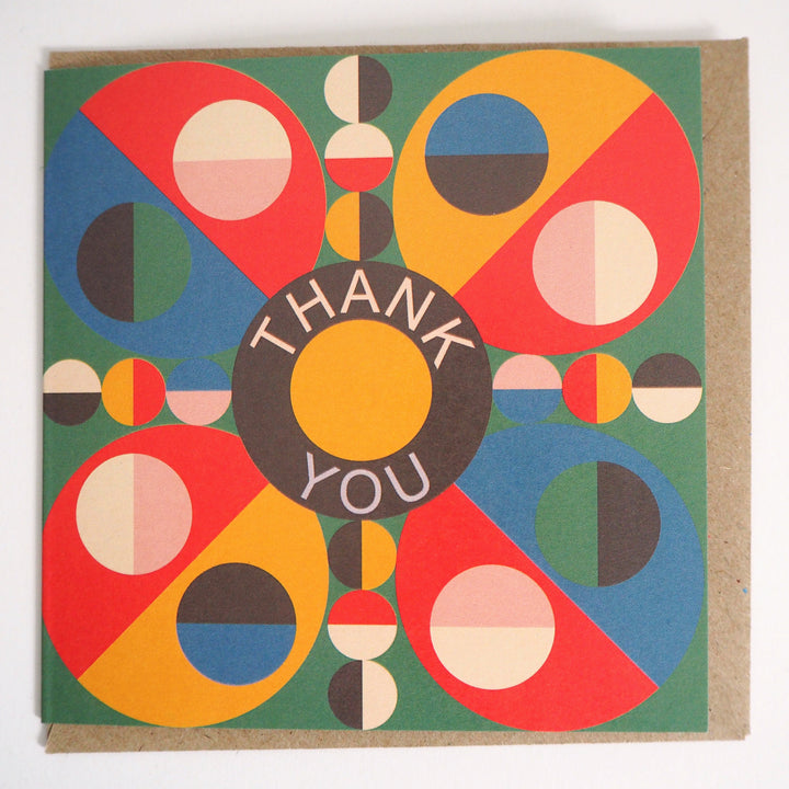 Express your gratitude with these striking modern thank you cards featuring bold geometric designs from Bright Stem. Sold by the Artist. Each set includes 12 cards with three unique patterns (4 of each design) accompanied by matching recycled brown paper envelopes. The vibrant colour palette combines rich reds, blues, greens, and yellows in an eye-catching circular motif, with each design centred around a distinctive 'Thank You' message. Measuring 12 x 12 cm