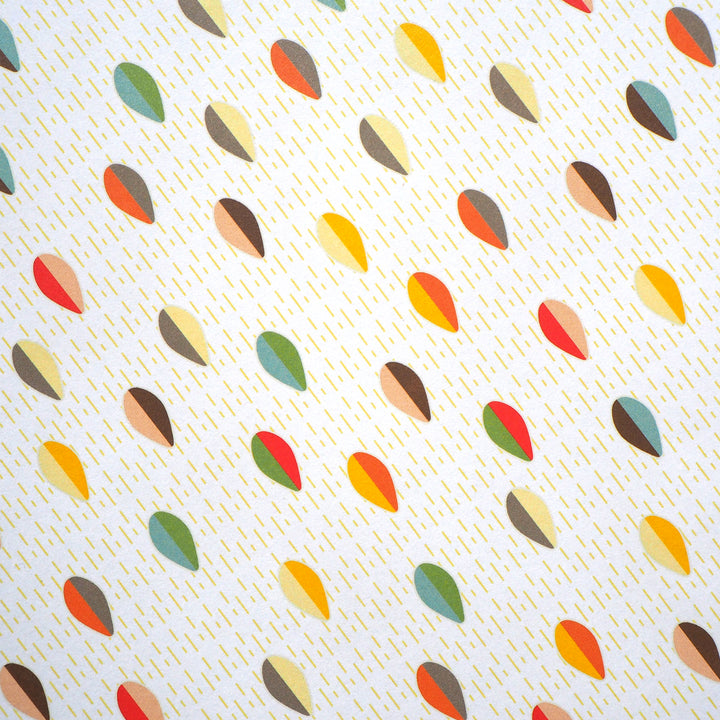 Bright Stem recyclable wrapping paper. Geometric abstract pattern made of multicoloured egg/leaf shapes on a white background with yellow lines. Close up