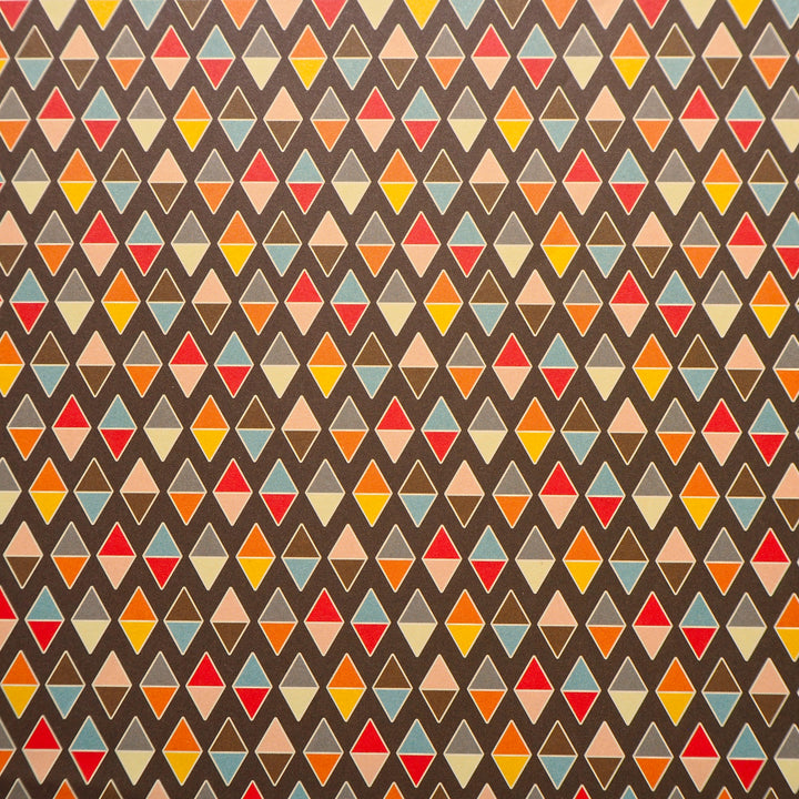Bright Stem recyclable wrapping paper. Geometric diamond pattern made of multicoloured triangles on a chocolate brown background. Close up


