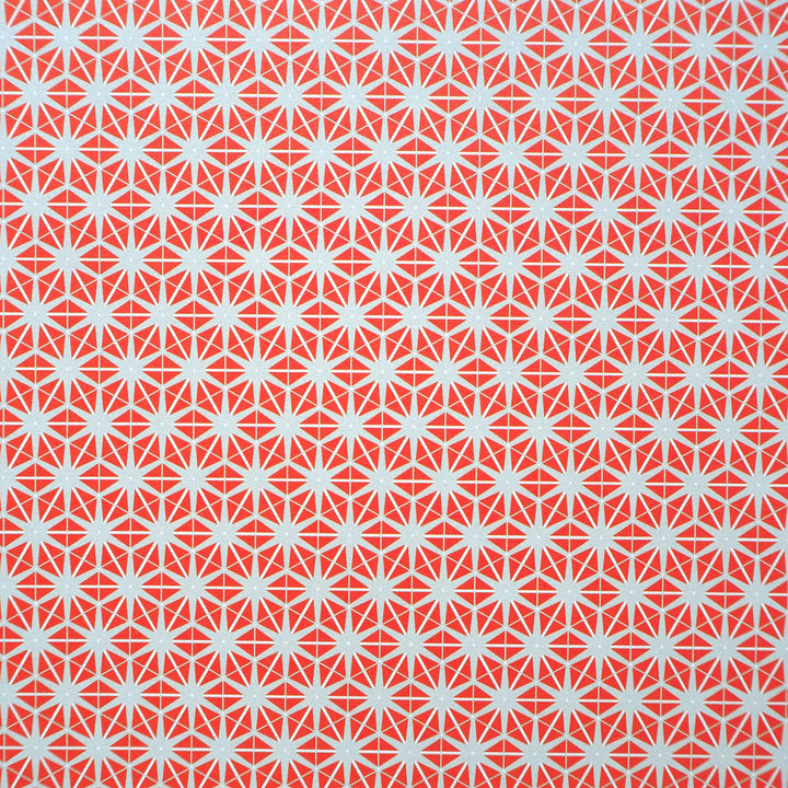 Bright Stem recyclable wrapping paper. Geometric star pattern made of orange triangles on a grey background. Close up