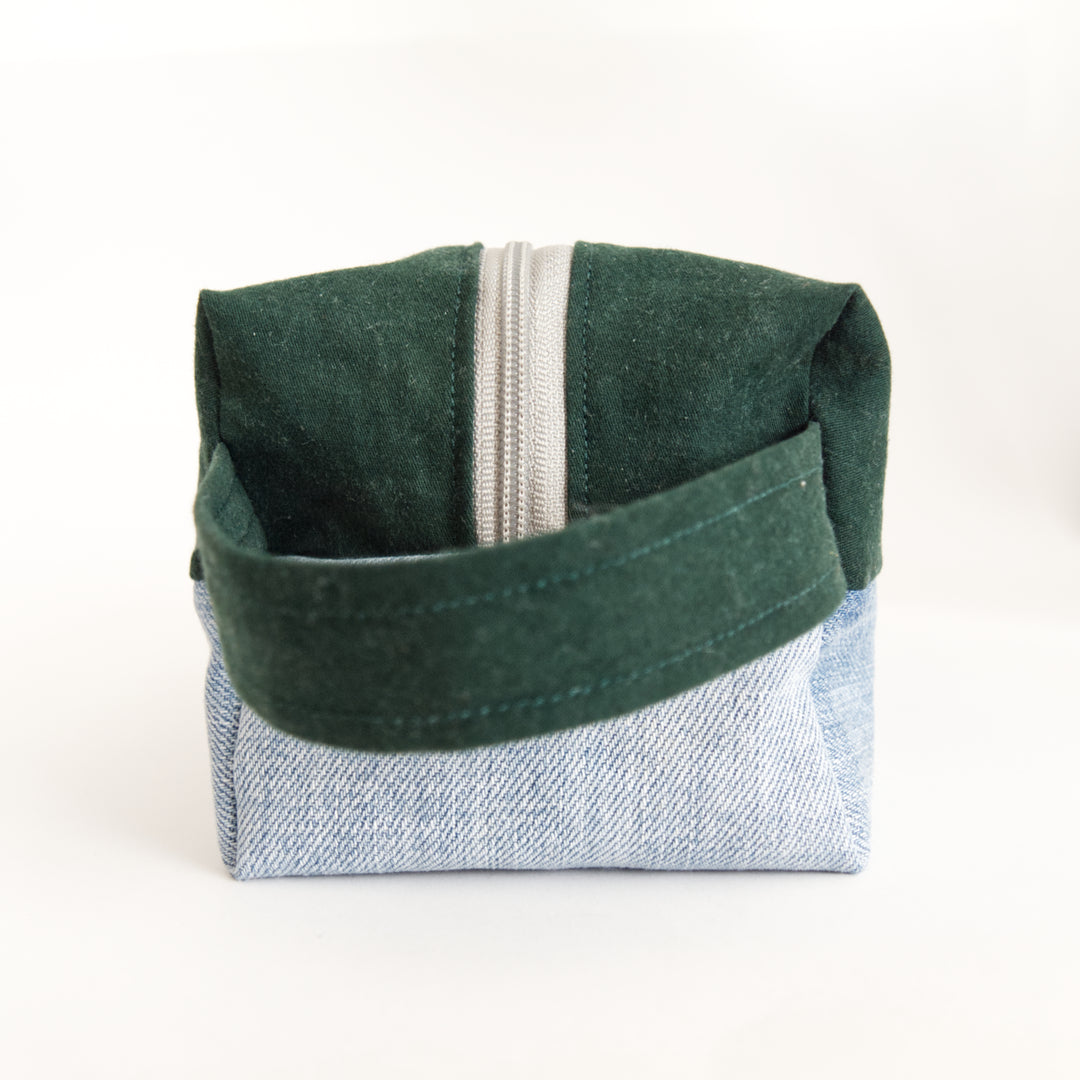 Bright Stem wash bag. Narrow side with handle. Made from green cotton and light blue denim upcycled fabric with a yellow and white cotton inner lining.