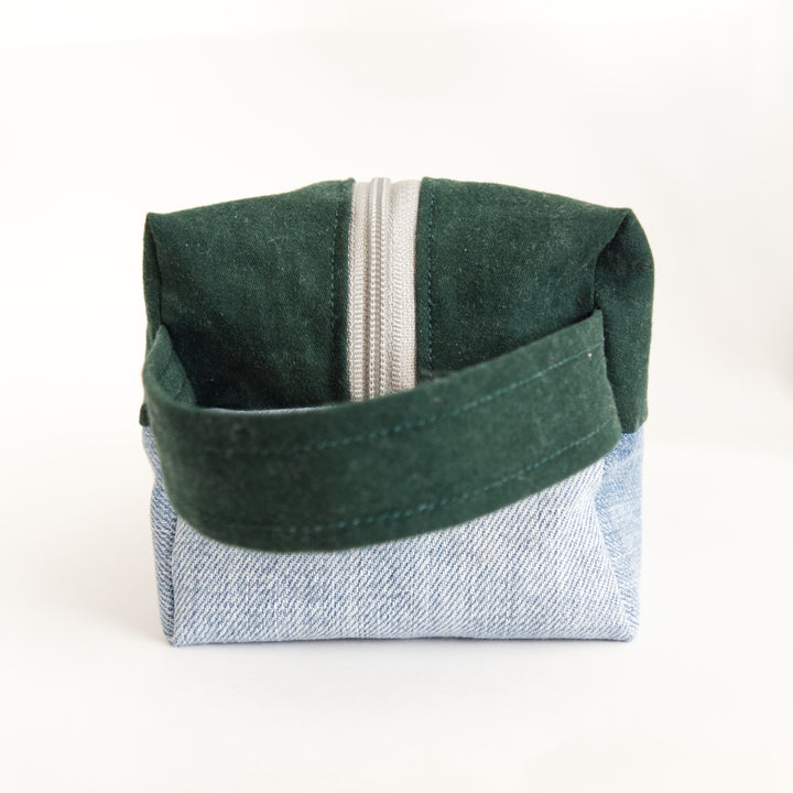 Bright Stem wash bag. Narrow side with handle. Made from green cotton and light blue denim upcycled fabric with a yellow and white cotton inner lining.