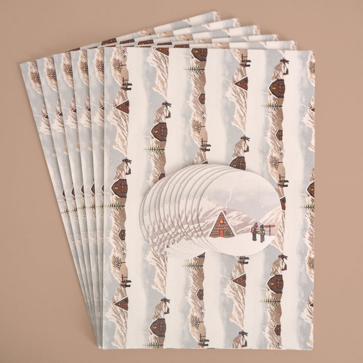 Stack of 6 folded sheets of recyclable Christmas wrapping paper with winter landscape illustration printed on. And 12 matching Christmas tags. From Bright Stem