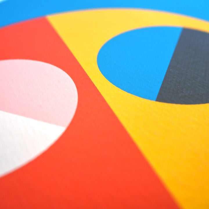 Close-up of a contemporary art print with colourful geometric abstract design with red, yellow, cream, pink, blue, and black semi circles. Printed on high quality watercolour paper.