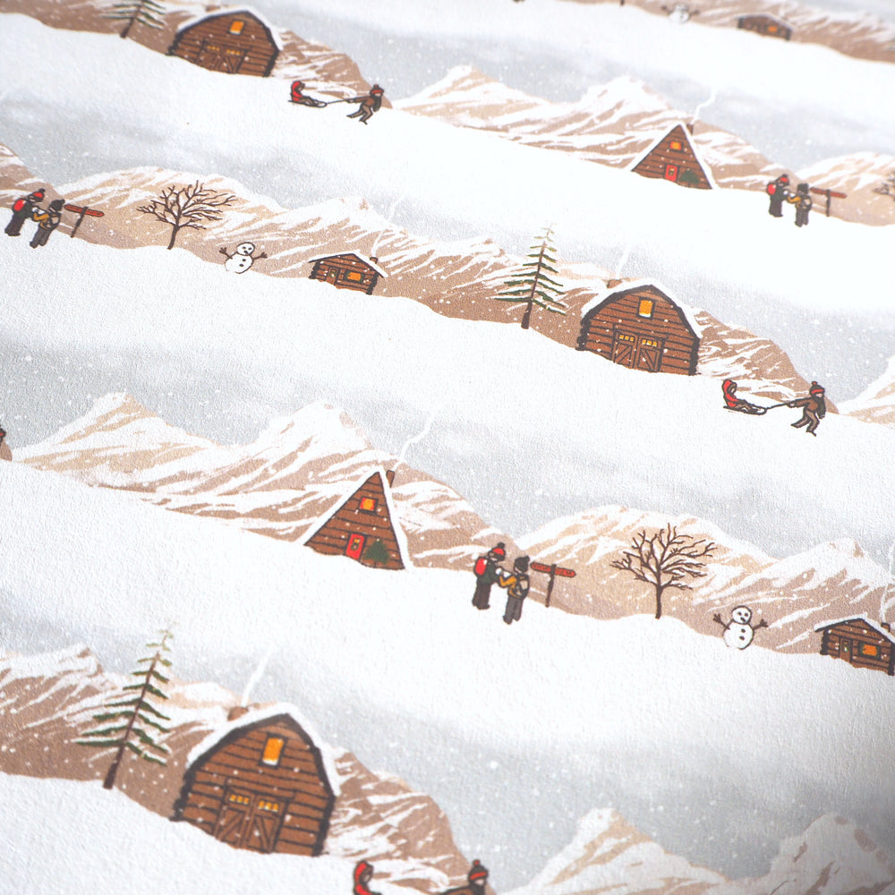 Bright Stem Christmas Wrapping Paper - Pattern of snow-covered mountains and cabins with people sledging and walking.