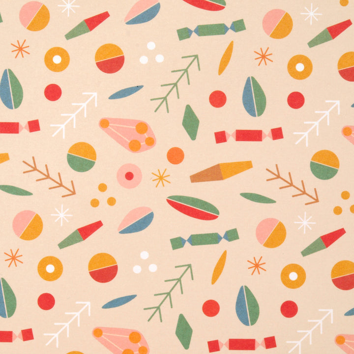 Close up of Christmas wrapping paper pattern featuring a colourful mix of Christmas themed and abstract geometric shapes on a cream background