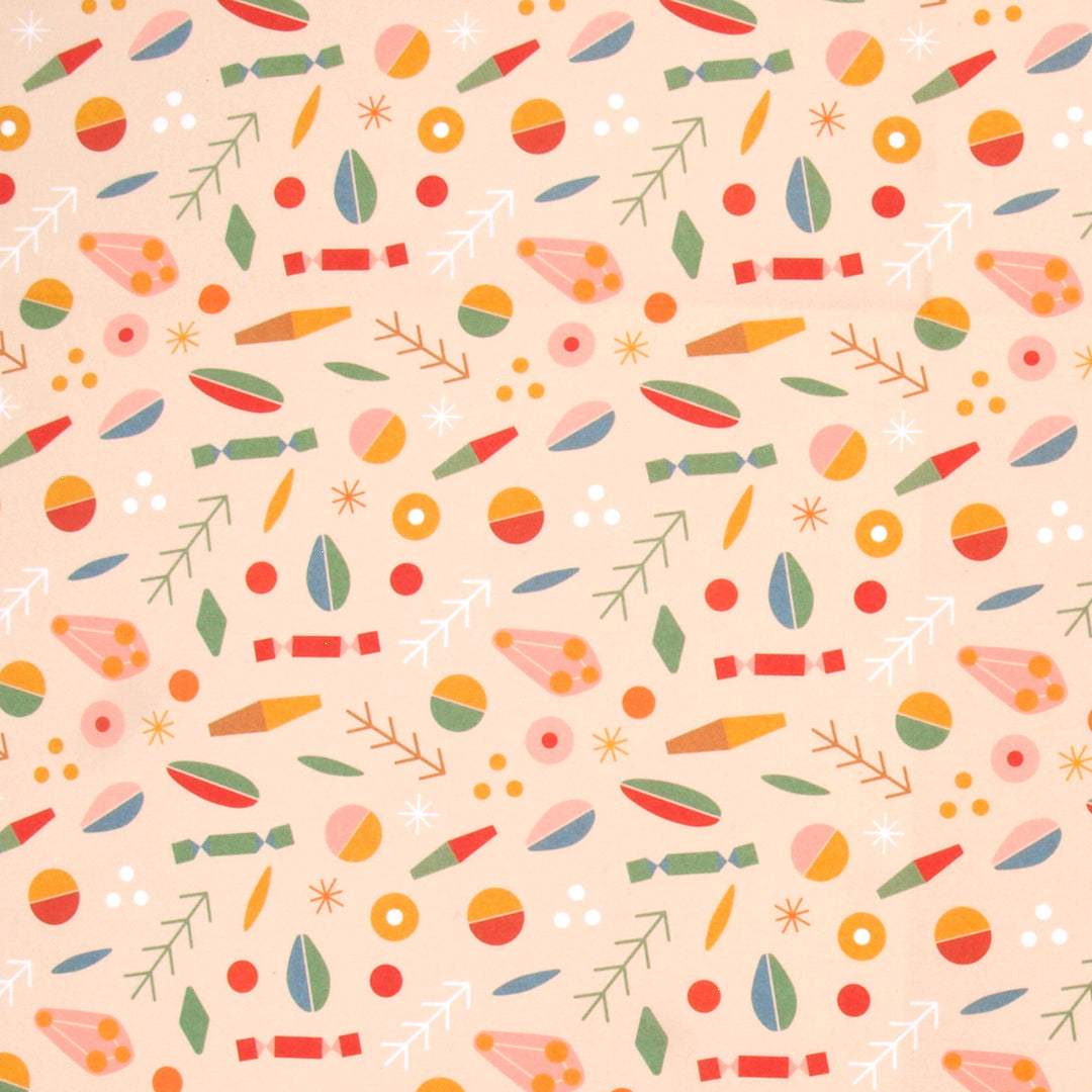 Close up of wrapping paper a colourful pattern of abstract shapes and Christmas crackers on a cream background