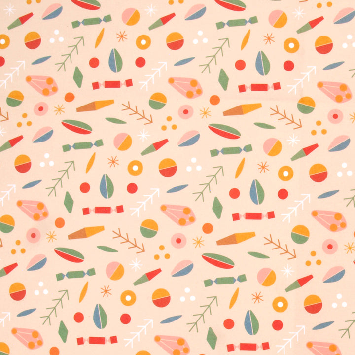 Close up of wrapping paper a colourful pattern of abstract shapes and Christmas crackers on a cream background