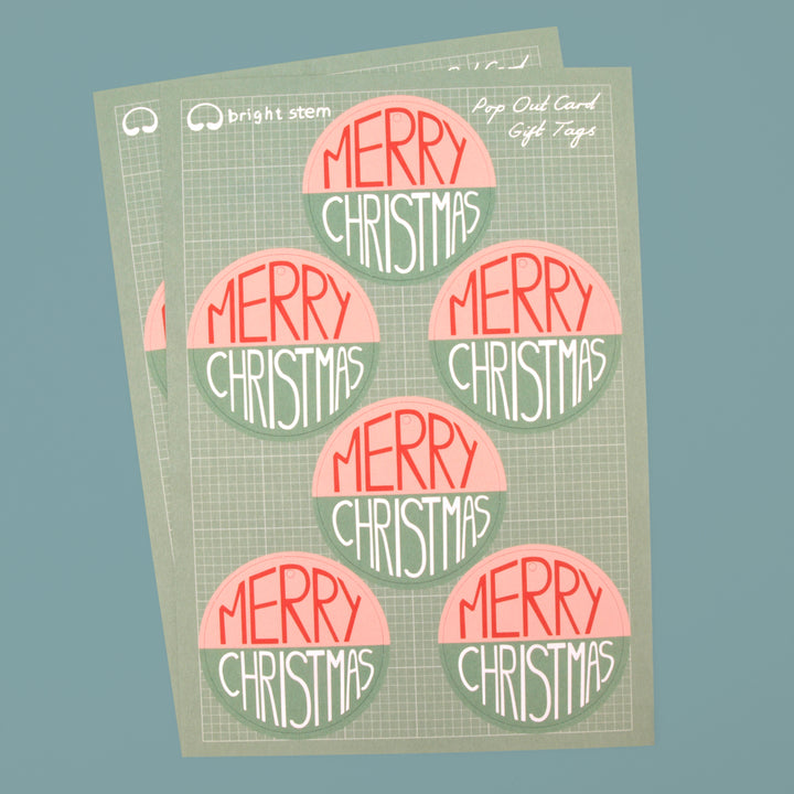 Two Sheets of 6 circular bright stem pop out tags with 'Merry Christmas' written across them. 12 tags in total.