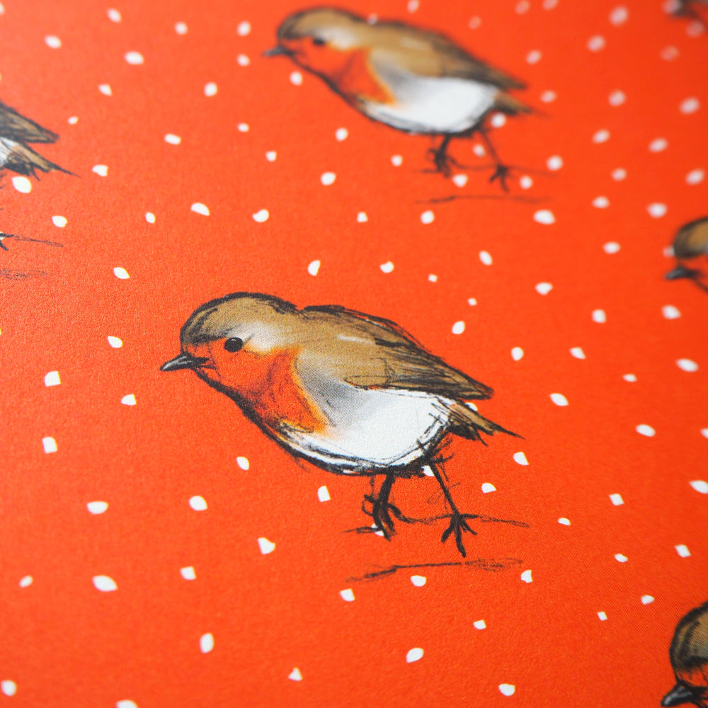Hand illustrated pattern of a Robin bird on an orange background with white spots of snow. Design for Christmas Wrapping Paper 