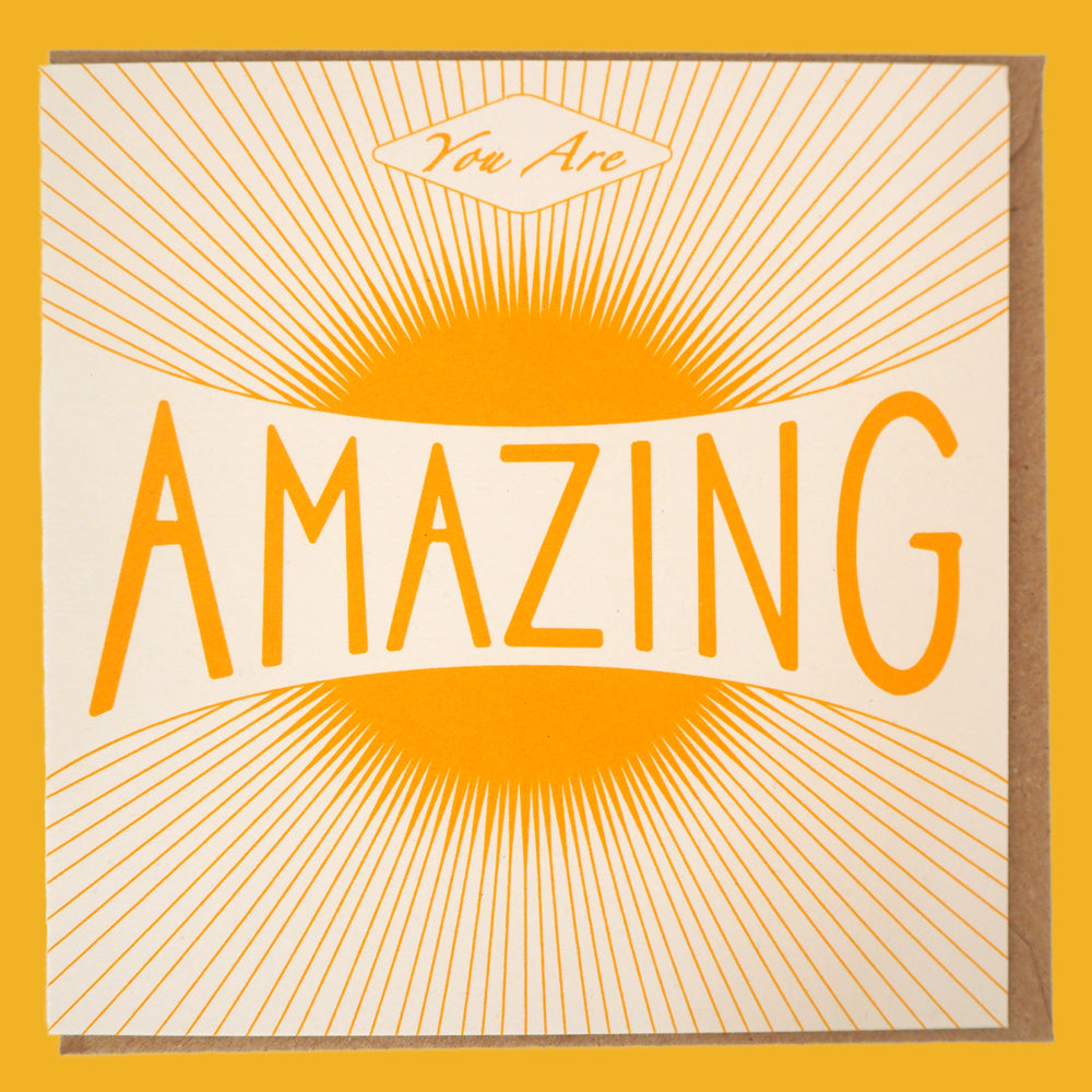 Bright Stem congratulations card. Featuring a warm vintage-style sun illustration and the uplifting message "You Are Amazing," laid flat with Kraft envelope inside.