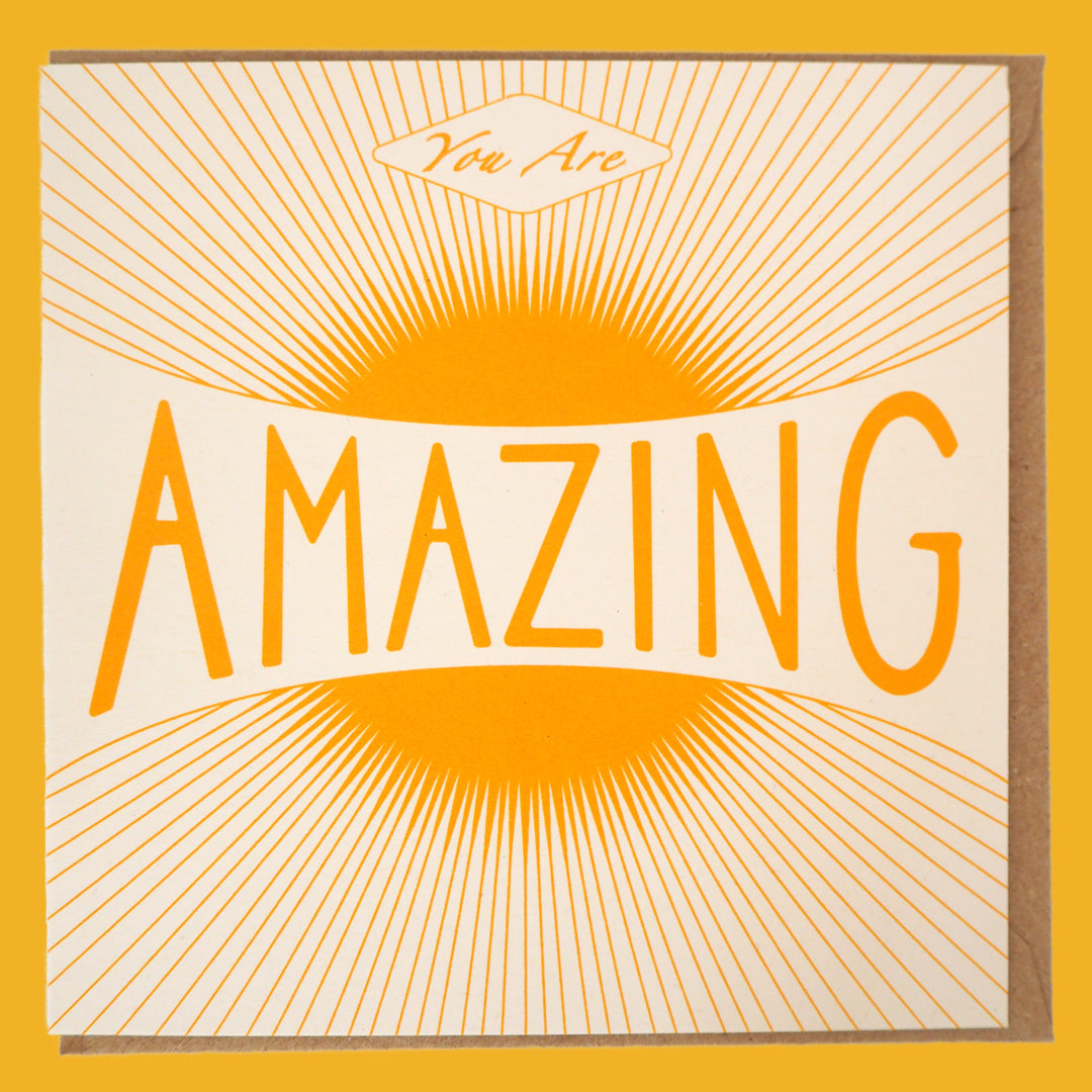 Bright Stem congratulations card. Featuring a warm vintage-style sun illustration and the uplifting message "You Are Amazing," laid flat with Kraft envelope inside.