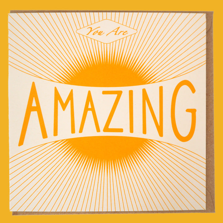 Bright Stem congratulations card. Featuring a warm vintage-style sun illustration and the uplifting message "You Are Amazing," laid flat with Kraft envelope inside.