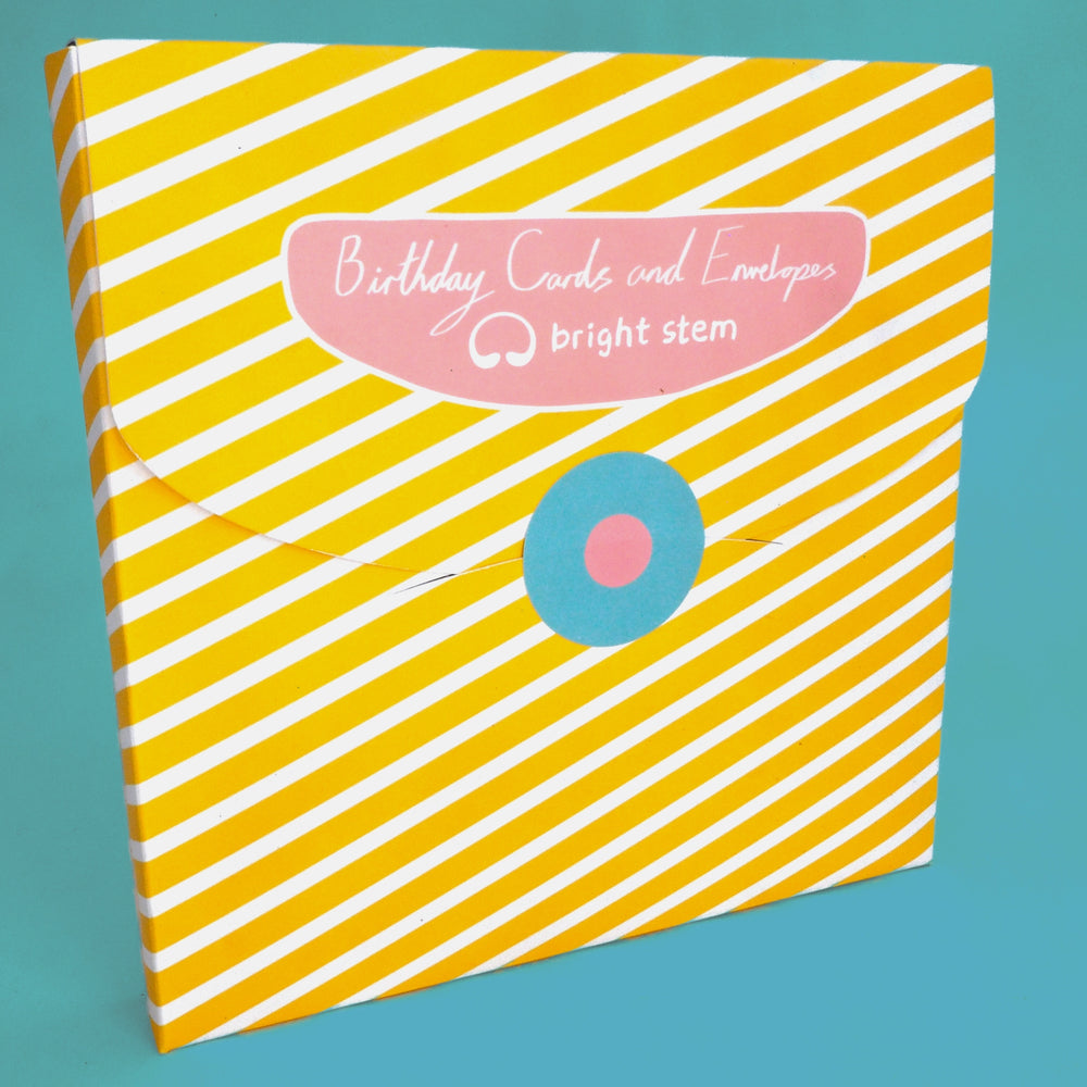 Packaging for bright stem birthday cards and envelopes with yellow and white striped design,  with blue and pink circular sticker.