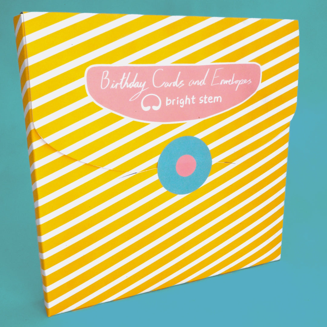 Packaging for bright stem birthday cards and envelopes with yellow and white striped design,  with blue and pink circular sticker.