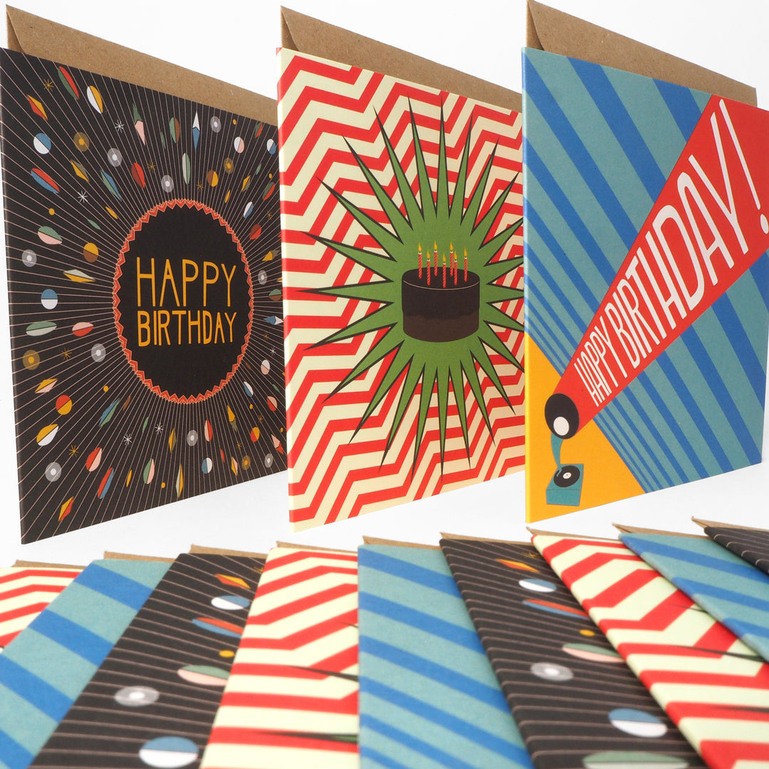 Collection of colourful bright stem birthday cards with various vintage style designs featuring abstract graphics illustrations of chocolate cake and an old record player. Displayed on a white background. 