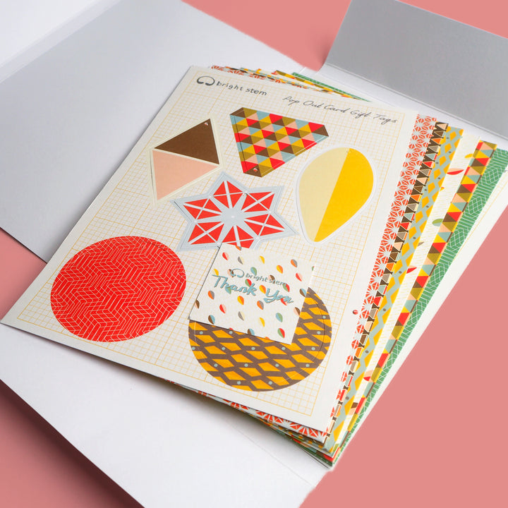 Recyclable Geometric Pop out tags and wrapping paper folded and displayed in a cardboard folder. 