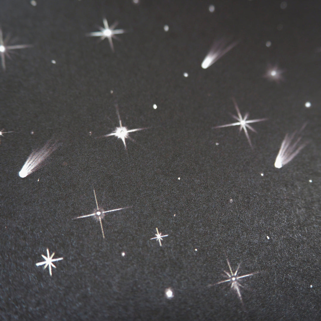wrapping paper pattern of a Starry night sky with comets and stars on a dark background