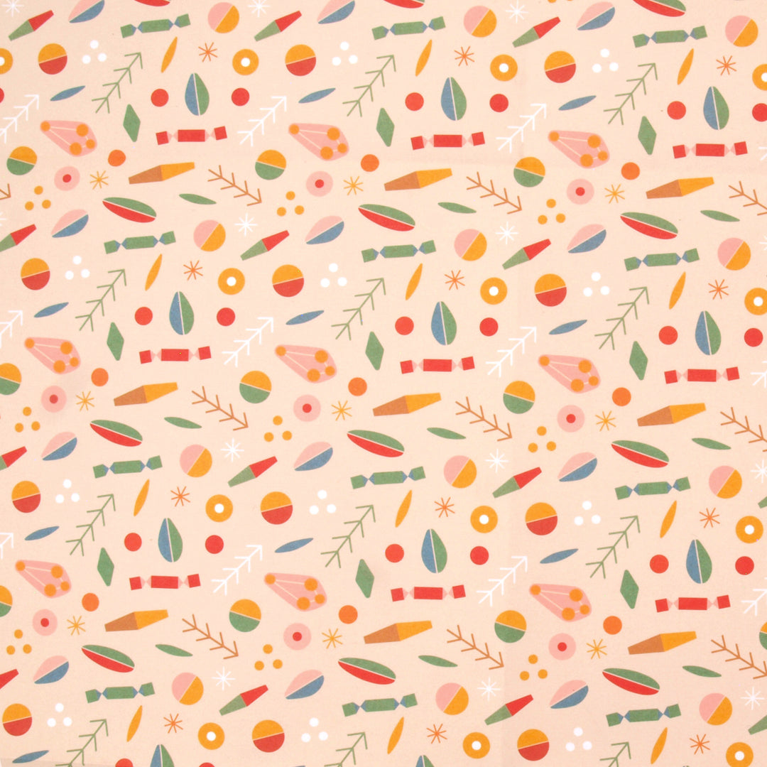 Close up of wrapping paper a colourful pattern of abstract shapes and Christmas crackers on a cream background