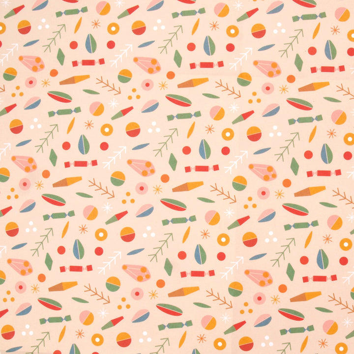 Close up of wrapping paper a colourful pattern of abstract shapes and Christmas crackers on a cream background