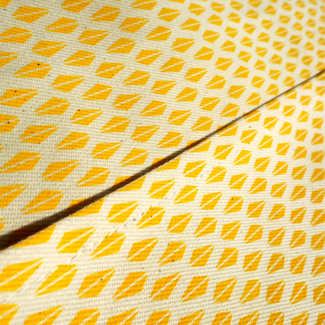 Bright Stem apron close up detail image of  pocket edge showing Yellow Triangle Pattern. With two symmetrical triangles making a diamond shape.