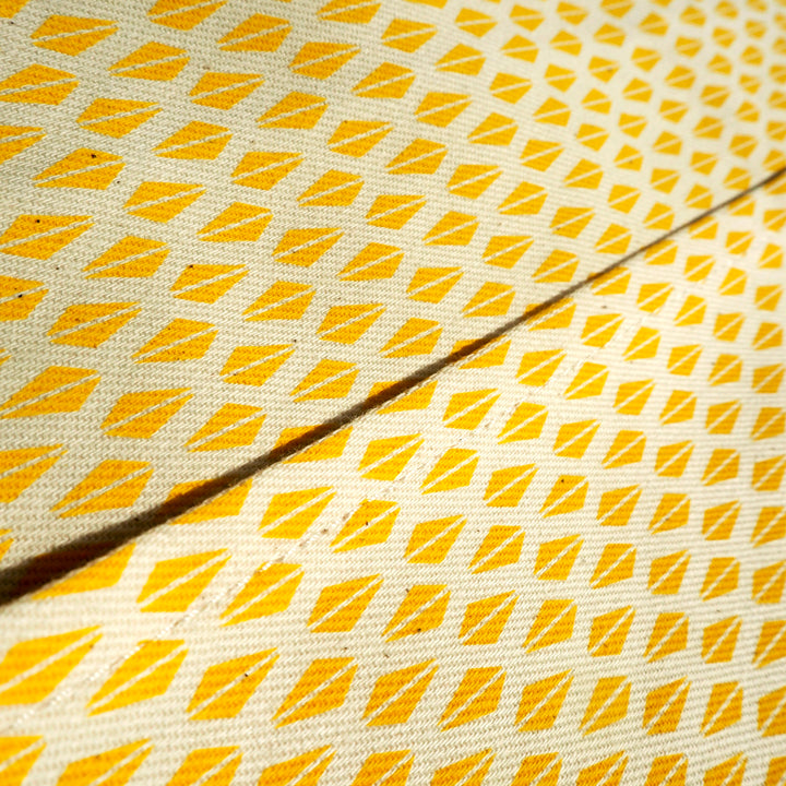 Bright Stem apron close up detail image of  pocket edge showing Yellow Triangle Pattern. With two symmetrical triangles making a diamond shape.