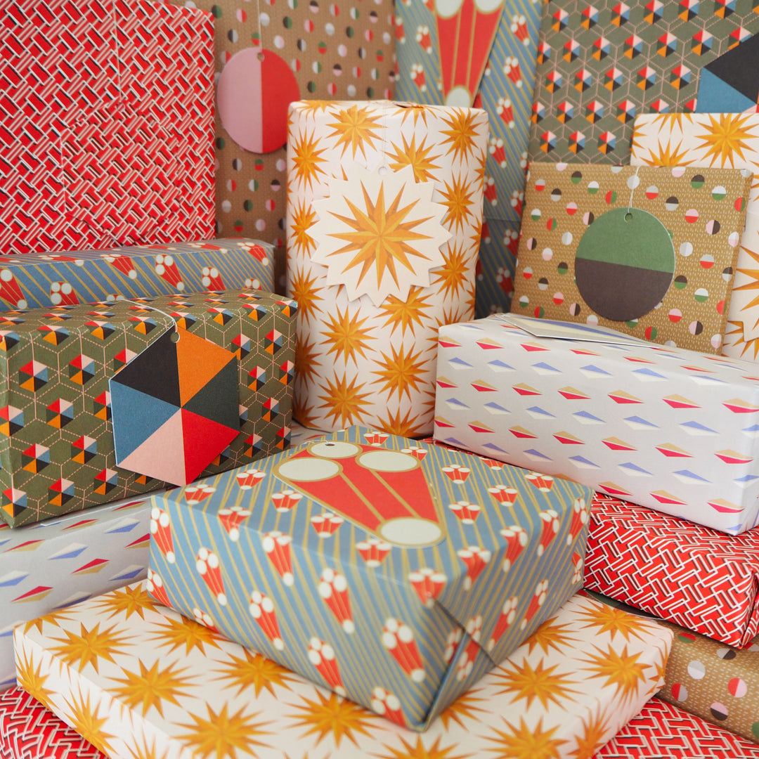 bright stem gift-wrapped presents with matching tags. Recyclable Gift Wrapping Paper Geometric unique multicoloured designs Vintage Style Patterns. Stars sculptures, triangles hexagons. early 20th century, modernist, art deco style designs, ethically manufactured, made in the UK, recycled sustainable