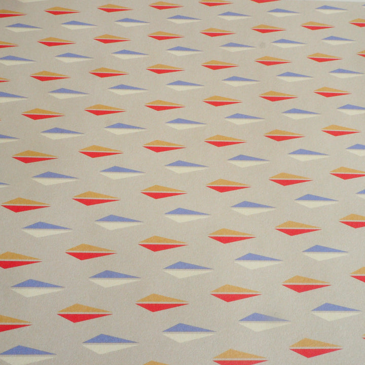 bright stem close up of sheet of Recyclable Gift Wrapping Paper Geometric unique multicoloured triangledesign on grey background Vintage Style Pattern early 20th century, 50’s, modernist, festival of Britain design, multicoloured ethically manufactured, made in the uk,